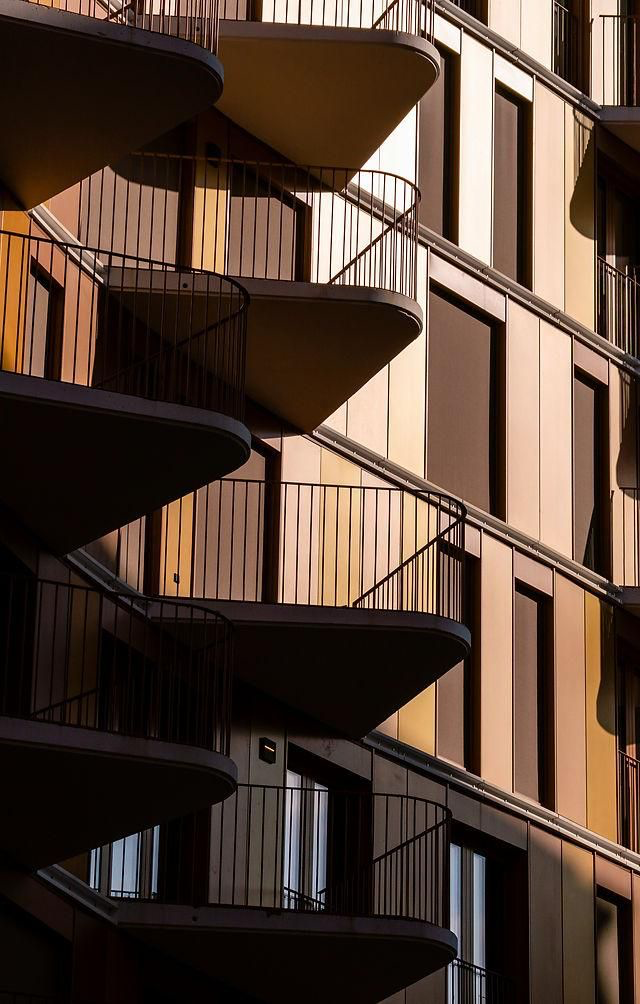 Warm golden light on a residential tower facade with curved balconies